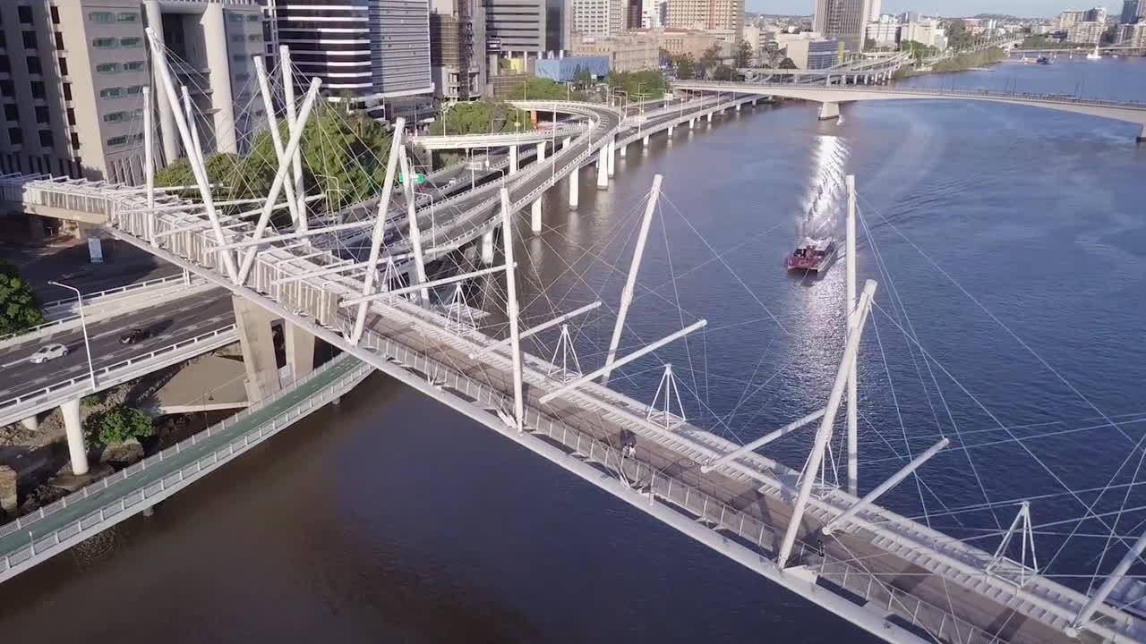 퀸즐랜드 브리즈번 강에서 항해하는 도시 고양이와 함께 쿠릴파 보행자 다리의 공중 틸트 샷
