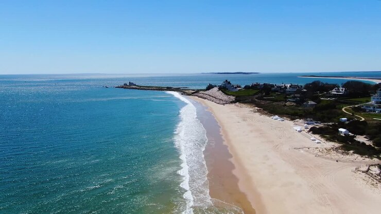 Onde oceaniche schiumose che si infrangono sulla costa tropicale e sabbiosa dell'America, vista aerea