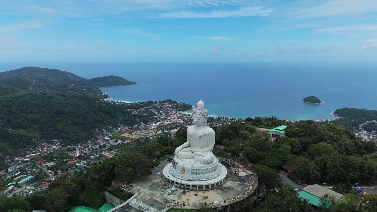 Máy bay không người lái bay vòng sang trái quanh Tượng Phật Lớn, cho thấy những ngọn đồi, đường bờ biển, bãi biển của Phuket và Biển Andaman ở Thái Lan