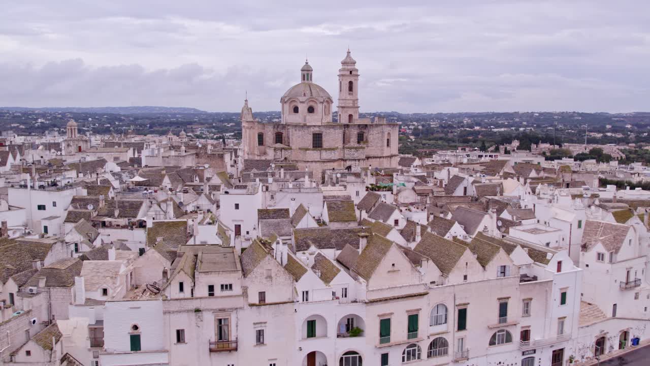 Vivace borgo bianco sotto un cielo nuvoloso e drammatico