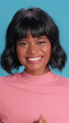 una mujer asiática y africana alegre sonriendo brillantemente contra un fondo vibrante