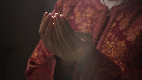 close up studio shot showing hands of muslim woman wearing hijab praying 1