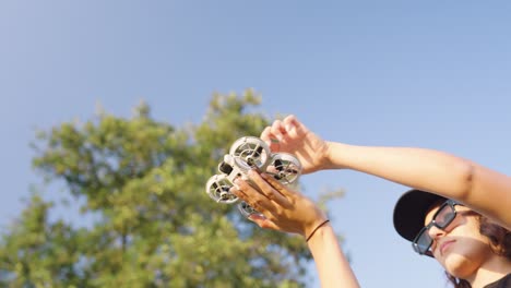 woman prepare compact drone for take off from her palm, czech republic