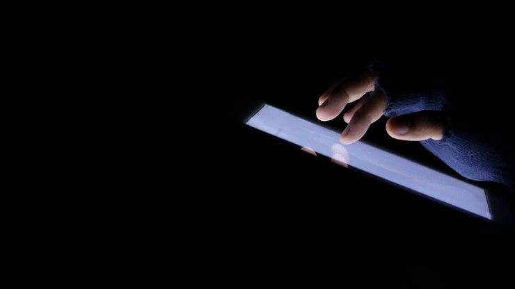 Persona che usa un tablet al buio