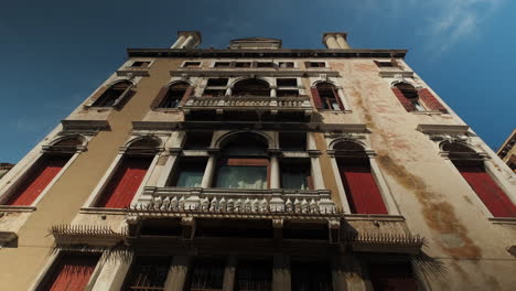 Incline-Hacia-Arriba-La-Toma-Inferior-Del-Antiguo-Edificio-Antiguo-Contra-El-Cielo-Azul-Y-La-Luz-Del-Sol-En-Venecia,-Italia