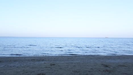 Frau-Mit-Strohhut-Läuft-Nach-Sonnenuntergang-Im-Strandsand