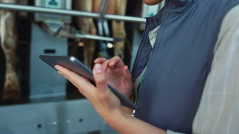 Worker-hands-touch-pad-closeup.-Livestock-owner-hold-tablet-in-milking-parlour.