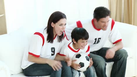 family in living room watching sport on tv