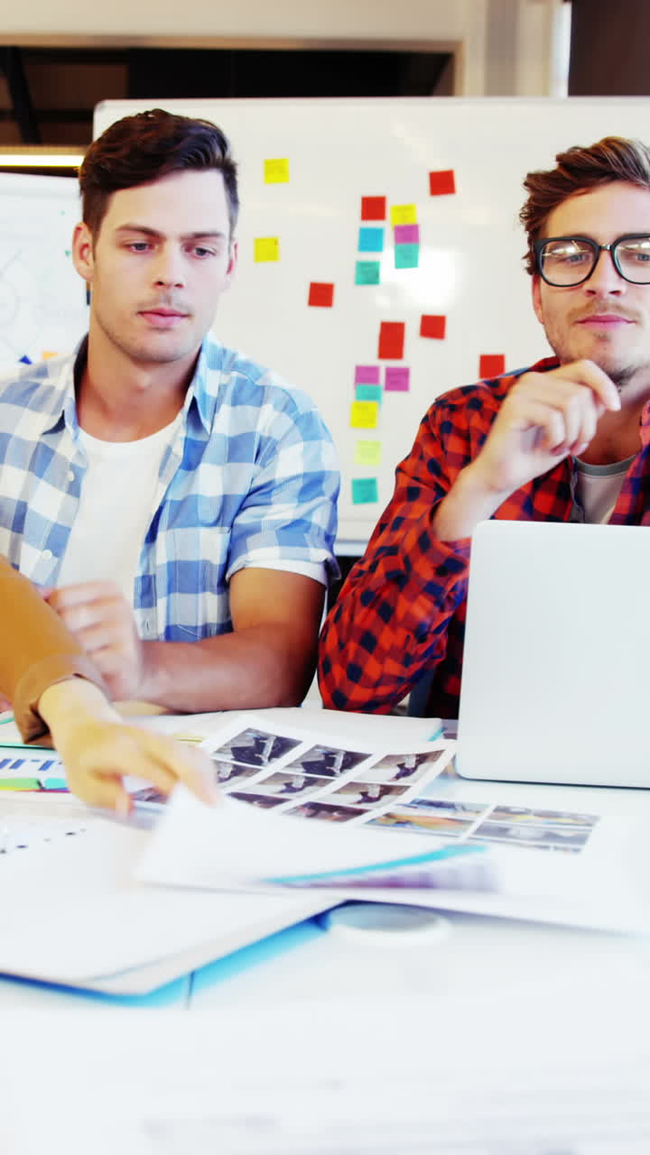diseñador gráfico con una muestra de foto e interactuando con sus colegas