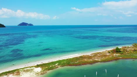 Peaceful-calm-lagoon-surrounded-by-natural-barrier-of-rocks-and-corals-from-deep-blue-sea-on-a-bright-cloudy-day-background-in-Thailand