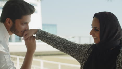 Close-up-of-handsome-muslim-man-kissing-hand-of-woman-outside.