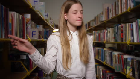 estudiante de secundaria dentro de la biblioteca recogiendo libros, disparo medio
