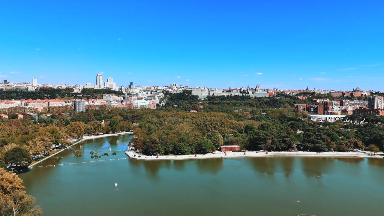 Bred droneudsigt over Lago de la Casa de Campo og Madrids bymæssige vartegn