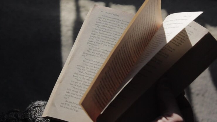 Pagine di libro che si sfogliano su una tonalità di texture delicata e sognante, con dettagli nitidi da vicino che poi si allontanano.