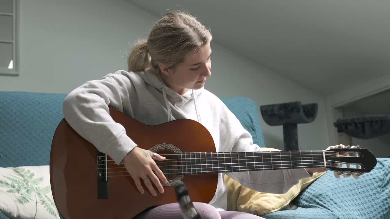 Young woman engaging in the art of tuning her acoustic guitar