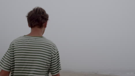 man walking on a foggy beach