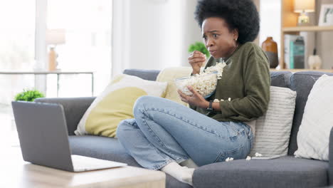 woman watching spooky horror movie on a laptop