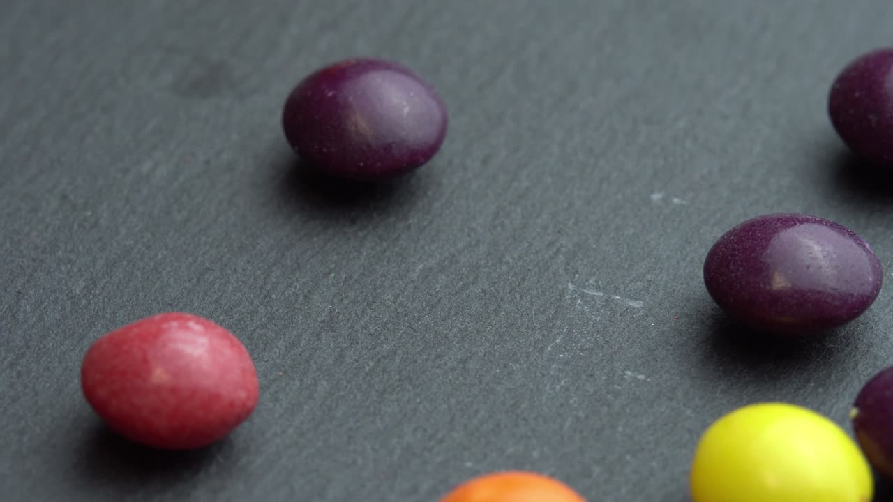 dulces de frutas de colores esparcidos sobre un fondo negro, dulces de marco de colores