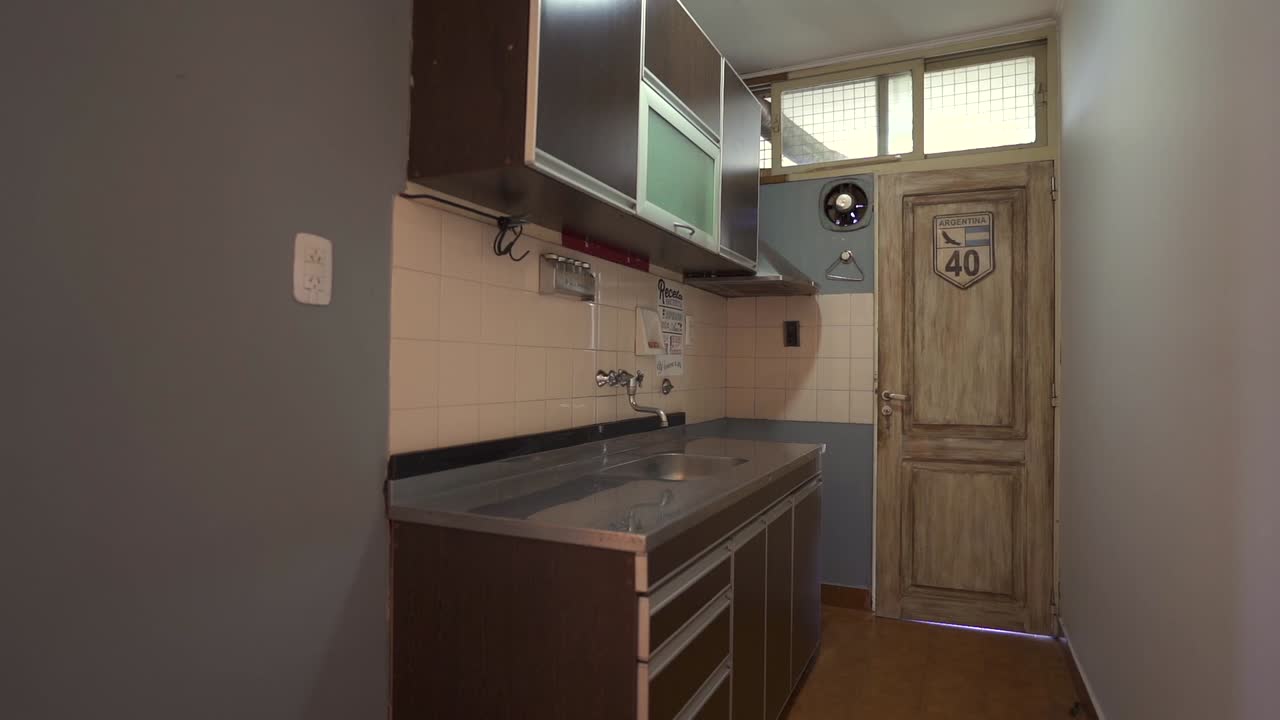 Slow glide reveals sleek, narrow kitchen’s functional layout and contemporary design, framed by entryway. Ideal for compact space showcases.