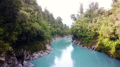 drone flight over a blue river in new zealand