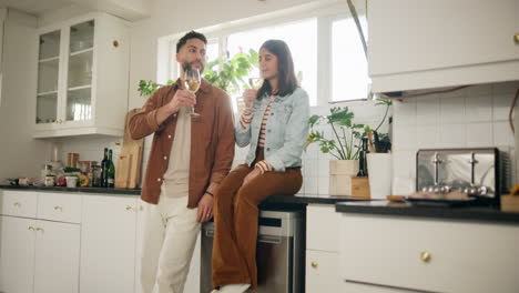 couple celebrating with wine in the kitchen