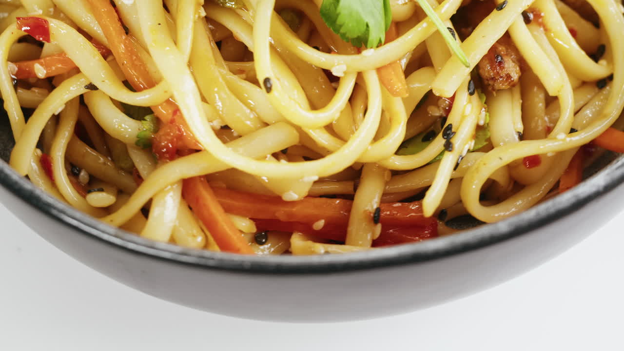 Bowl of noodles with vegetables and sesame seeds