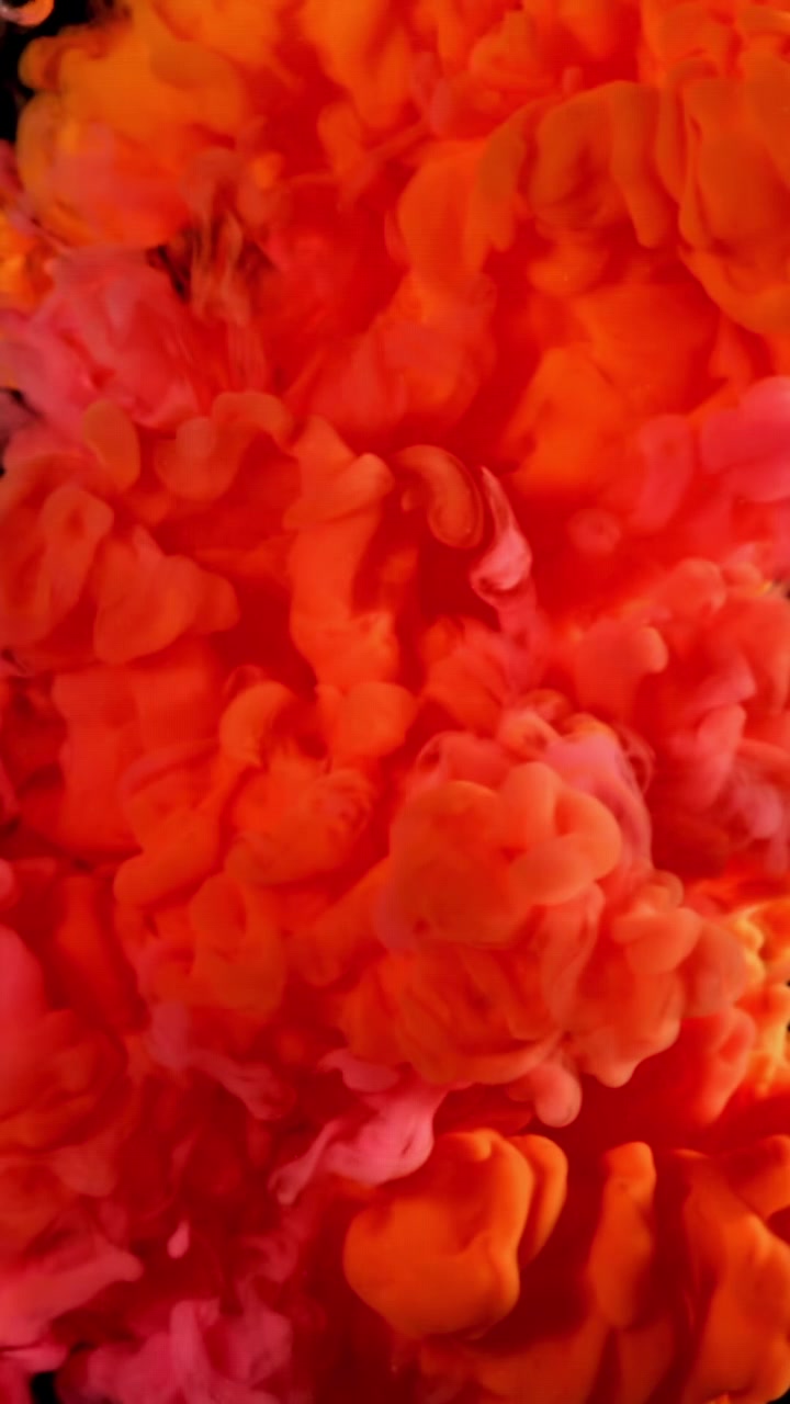 Vibrant Red and Orange Ink Swirling in Water on Black Background