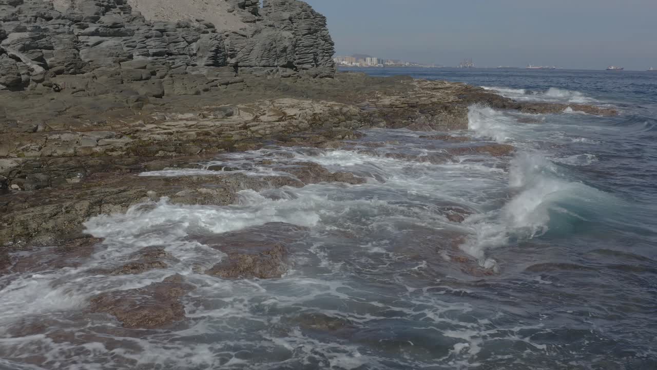 toma de drones de olas salpicando en la costa de un océano