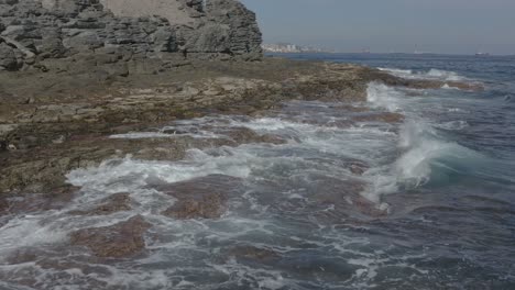 Drone-shot-of-waves-splashing-on-the-coast-of-an-ocean