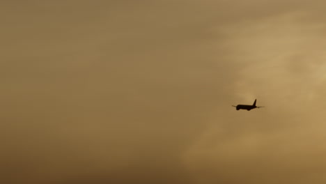airplane in a hazy sky at sunset/sunrise