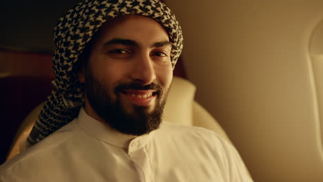 arab man travel business jet closeup. smiling businessman posing at plane window