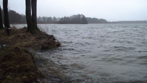 close up of fast lake river waves breaking towards the shore and splashing water drops