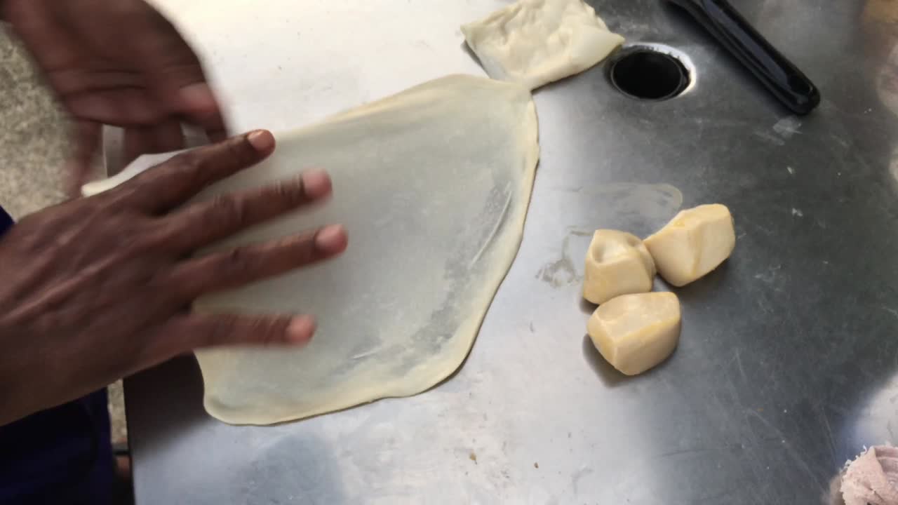 cocinar panqueques tailandeses exóticos, roti malaysian con diferentes rellenos en un mercado de tailandia. hacer rollo de roti de huevos en sartenes de metal calientes con aceite hervido. comida callejera de tailàndia. postre tailandés.