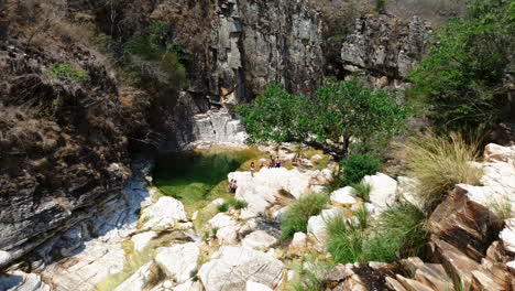 Hidden-oasis-in-the-mountains-from-above,-panning-down-shot