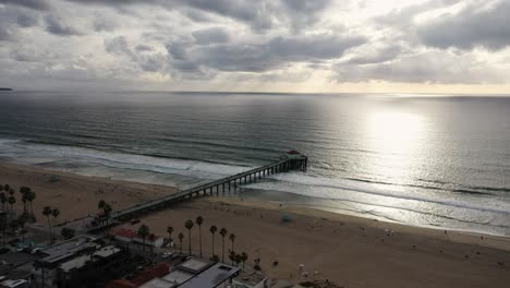 view of the seafront with a jetty at sunset, bird's eye view motion