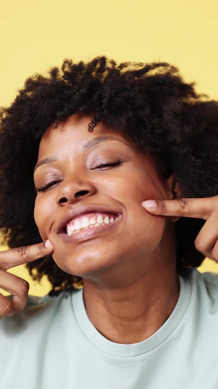 Giovane donna afroamericana gioiosa che sorride e ride