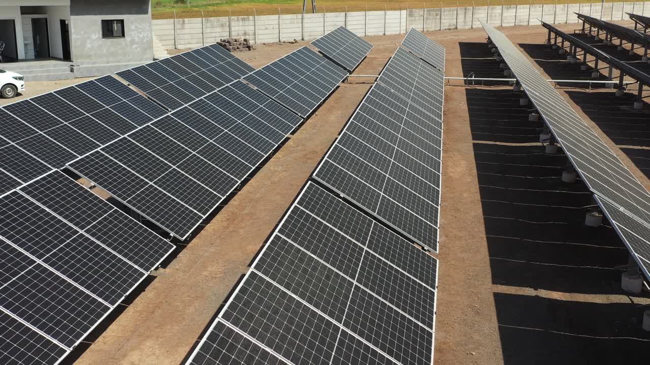 aerial drone view of large solar panels at solar farm at bright sunset in early winter solar cell power.4k video