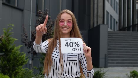 cheerful girl showing up to 40 percent off text advertisement. online shopping with low prices