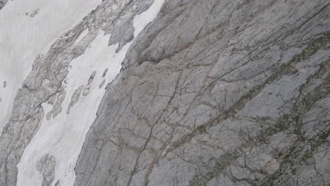 Top-down-drone-footage-of-a-cliff-and-snow-at-the-Vignemale-in-the-Pyrenees-moutains