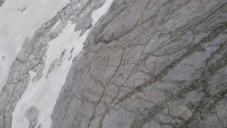 top-down drone footage of a cliff and snow at the vignemale in the pyrenees moutains