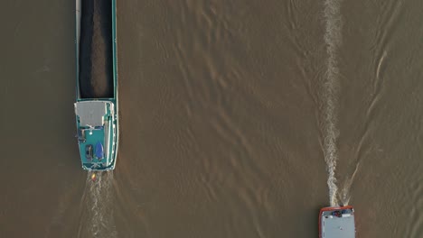 Top shot of two ships boats meeting meet each other load and transport coal, petrol and gas with a radar device on the brown river rhine 25p