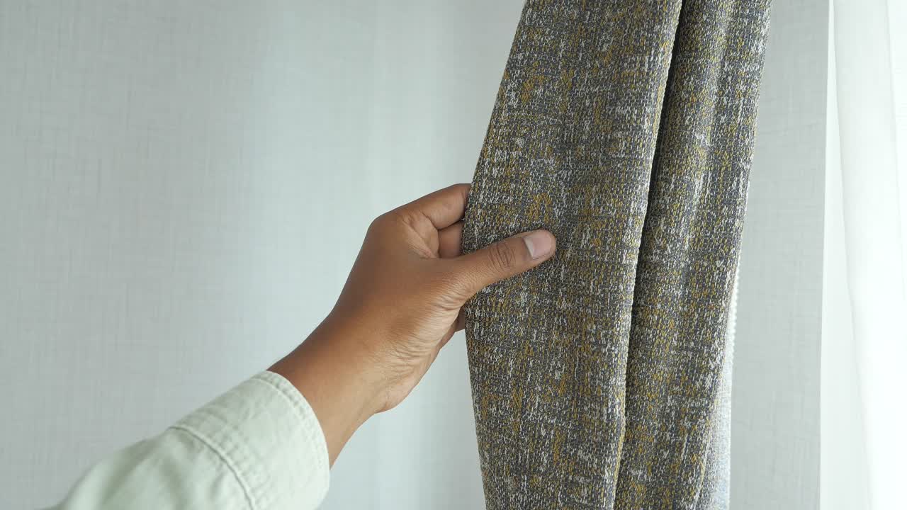 회색 과 베이지색 의 커튼 을 조정 하는 사람