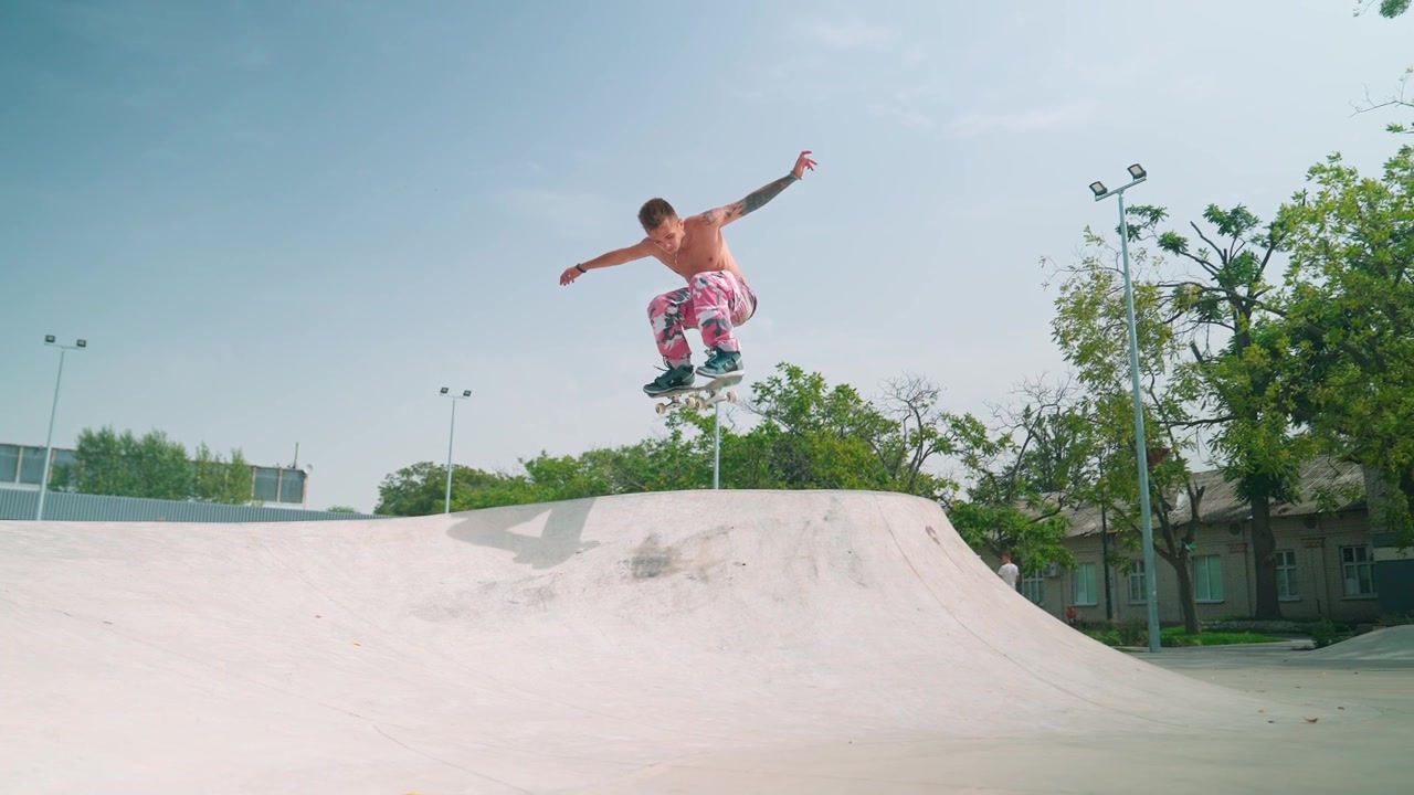 Giovane skater che esegue un trick ollie in uno skatepark all'aperto.
