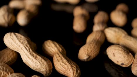 bunch of peanuts drop from above onto black table