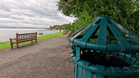 a bench and bin by the sea