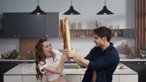 Hombre-Y-Mujer-Peleando-Con-Rodillos-En-La-Cocina.-Pareja-Divirtiéndose-En-Casa