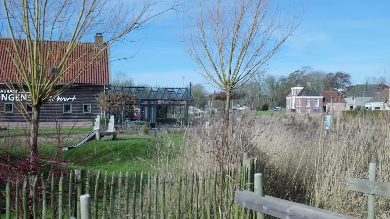 Idyllisch dorpslandschap met kanaal, riet en traditionele huizen