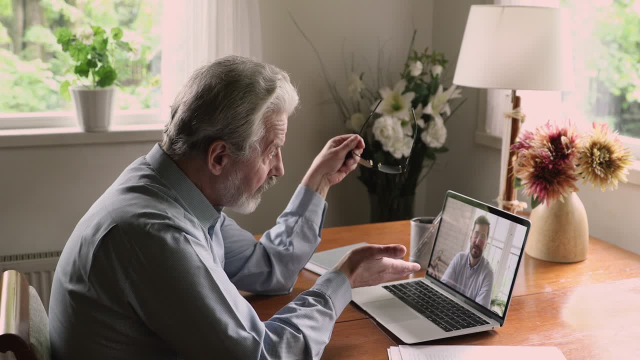 Young and mature business men talking remotely by videocall