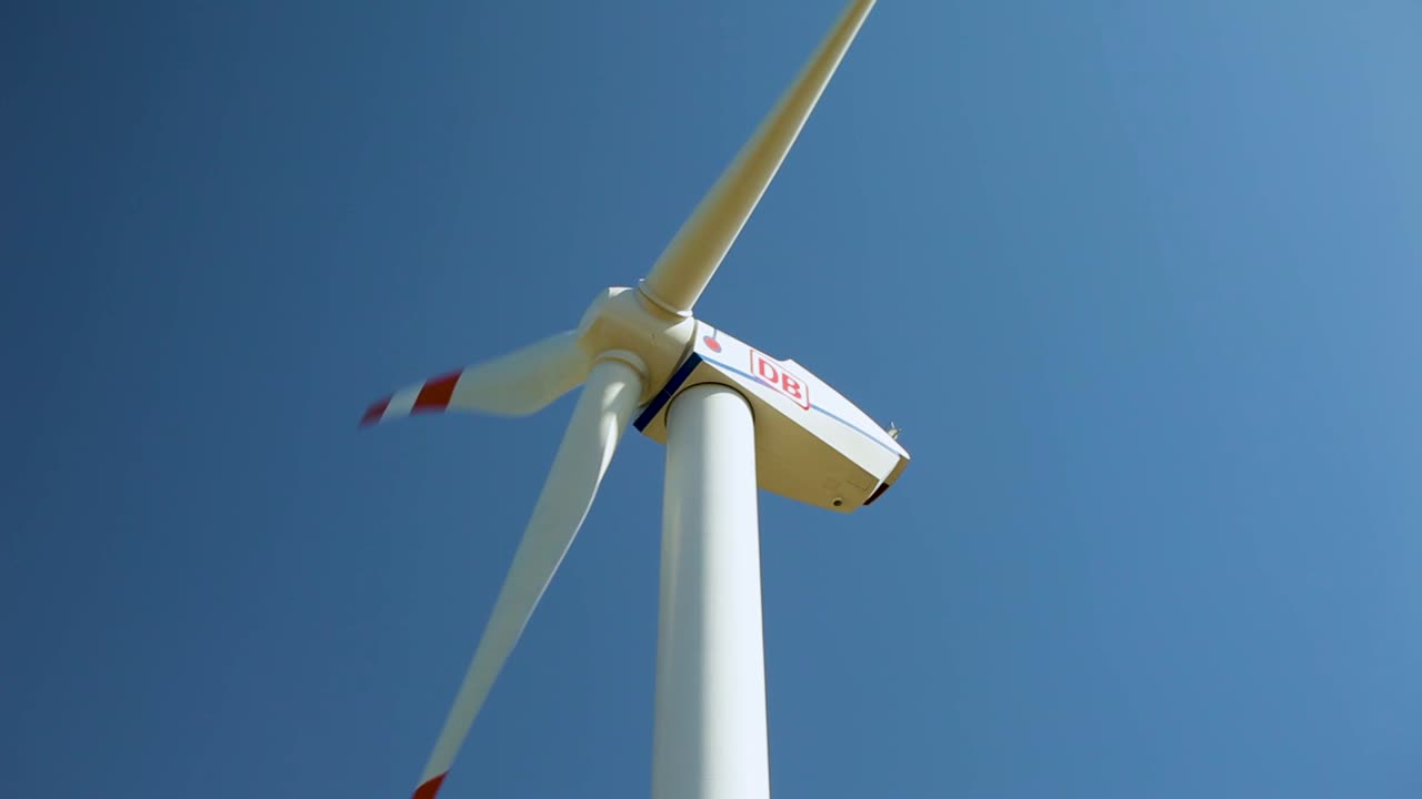 A close-up view of a wind turbine generating power against a clear blue sky