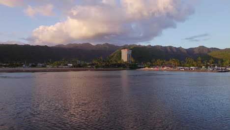 Toma-Estacionaria-Del-Este-De-Honolulu,-Hawaii,-En-La-Isla-De-Oahu,-Con-El-Rosa-Del-Sol-Poniente-Reflejándose-En-El-Agua-Con-Montañas-De-Color-Púrpura-Que-Bordean-El-Horizonte.